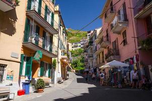 manarola, italia gente turistas caminando por la calle con edificios coloridos multicolores foto