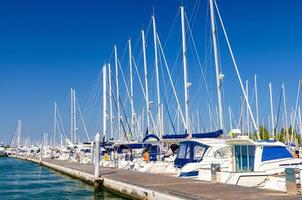 White yachts are moored on water of pier parking in marina port harbour of Sottomarina town photo