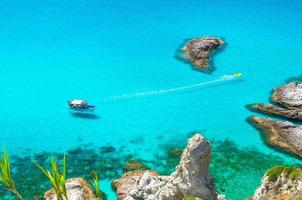 Fishing yacht and rubber boat in Capo Vaticano lagoon, Calabria, Italy photo