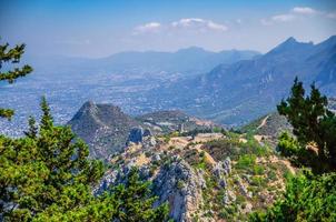 Kyrenia Girne mountain range from medieval Saint Hilarion Castle with green trees and rocks photo