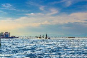 Yacht boats racing sailing on water of Venetian lagoon between wooden poles near Venice city photo