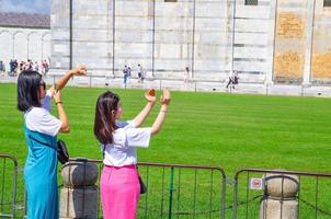 turistas viajeros caucásicos y asiáticos están posando, divirtiéndose foto