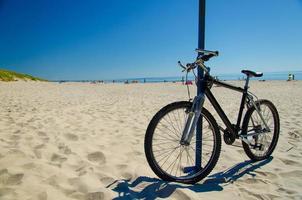 Bicycle on sandy yellow beach, Curonian Spit, Baltic sea, Lithuania photo