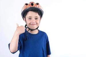 Child in a bicycle helmet shows gesture OK photo