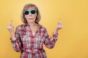 Portrait of senior woman insulting with finger photo