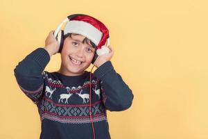 happy child Wearing Christmas Santa Claus Hat with headphones photo