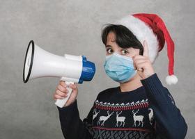 Merry Christmas,kid with medical mask screaming with megaphone photo