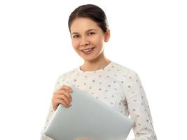 Smiling woman holding closed laptop computer photo