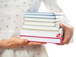 Woman holding stack of books closeup photo