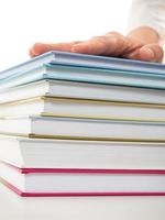 Stack of books with hand on top of it photo