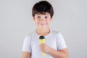 chico cantando con un microfono foto