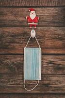 Merry Christmas.Protective surgical mask and santa claus figure photo