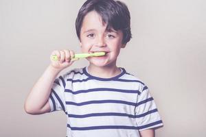 niño pequeño cepillándose los dientes foto