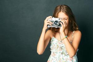 beautiful smiling girl with white teeth holding a instant camera photo