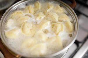 homemade dumplings in the kitchen without decorations. making dumplings with minced pork, beef and chicken photo