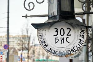 Moscow,Russia-February 23,2019. Vintage hanging metal plaque with house number with writing Museum of Bulgakov on the museum of the famous Russian writer Mikhail Bulgakov. photo