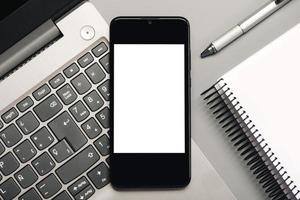 teléfono inteligente con pantalla blanca para copiar espacio con computadora portátil y portátil foto