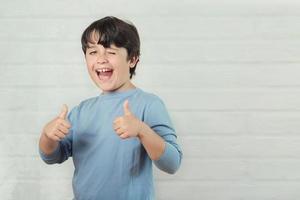 Little boy smiling showing thumbs up photo