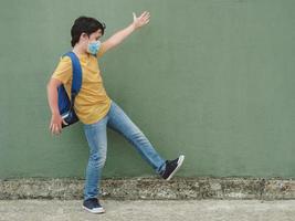 happy kid with medical mask and backpack going to school photo