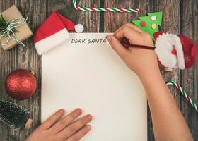 feliz navidad.fondo del concepto de navidad. niño manos escribiendo carta a santa claus