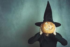 mujer joven sosteniendo una calabaza en halloween foto