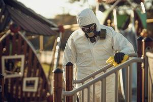 Cleaning and Disinfection on the playground in the sity complex amid the coronavirus epidemic Teams for disinfection efforts Infection prevention and control of epidemic Protective suit and mask photo