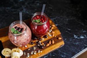 freshly prepared smoothies from banana with pomegranate and banana with blackberry in bottle. Diet, healthy lifestyle photo