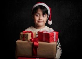 niño feliz con regalos de navidad foto