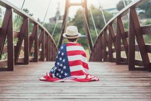 niño triste con la bandera de los estados unidos foto