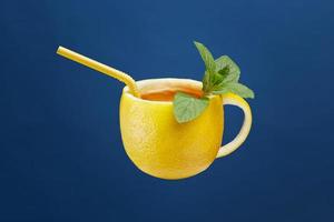 A cup of tea made from natural lemon with mint leaves. Creative composition on the theme of natural tea photo