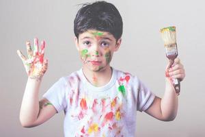 niño divertido con pintura y un pincel foto