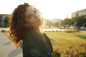 Portraits of a charming red-haired girl with freckles and a pretty face. The girl poses for the camera in the city center. She has a great mood and a sweet smile photo