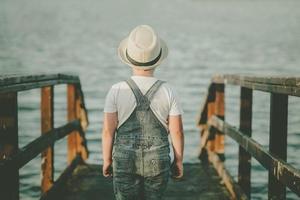 Back view of a Pensive child looking at the sea photo