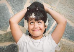 Happy child playing with kitten photo