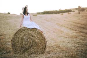 Smiling girl sitting on the straw photo