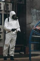 Cleaning and Disinfection on the playground in the sity complex amid the coronavirus epidemic Teams for disinfection efforts Infection prevention and control of epidemic Protective suit and mask photo