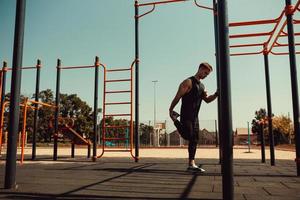 athletic guy warms up before classes on the horizontal bar photo