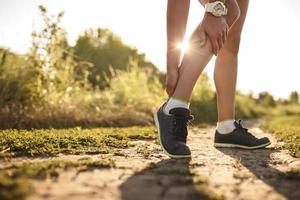 mujer corredora sostenga su pierna lesionada deportiva foto