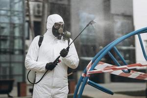 Cleaning and Disinfection on the playground in the sity complex amid the coronavirus epidemic Teams for disinfection efforts Infection prevention and control of epidemic Protective suit and mask photo