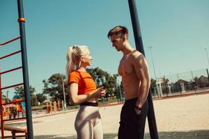 young couple communicates while standing by a horizontal bar photo
