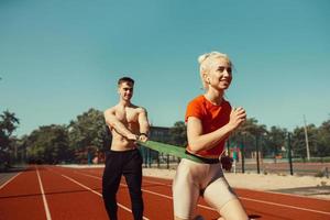 pareja joven haciendo deportes con gomas deportivas foto