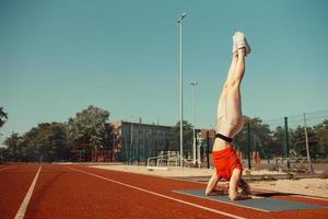 young blonde learns to balance in a headstand and handstand photo