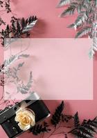 blank for decorating postcards or a gift certificate for a photographer. Old camera on a pink background with gray dried flowers and space for text photo