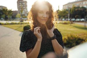 retratos de una encantadora chica pelirroja con pecas y una cara bonita. la chica posa para la cámara en el centro de la ciudad. ella tiene un gran humor y una dulce sonrisa foto