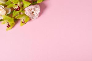 preparación para una futura postal. flores rosas sobre un fondo rosa con espacio para texto foto