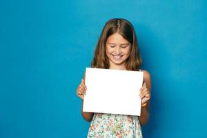 beautiful smiling girl with white teeth holding in hands white blank copy space for the announcement photo