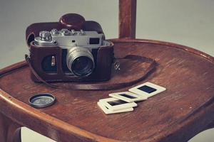 retro camera and old slides lay on a chair photo