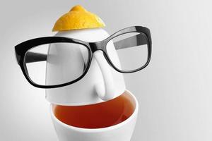 Creative composition on the theme of tea. Tea cups in the form of a human face with glasses