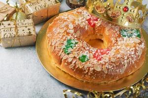 Roscon de reyes with cream and christmas ornaments. Kings day concept spanish three kings cake photo