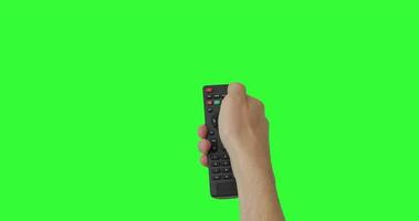 mano masculina aislada con el control remoto de la televisión presionando el botón para encender o apagar la televisión. pantalla verde. lugar para su anuncio. paquete de gestos. usando un control remoto sobre el fondo de la clave de croma. punto de vista